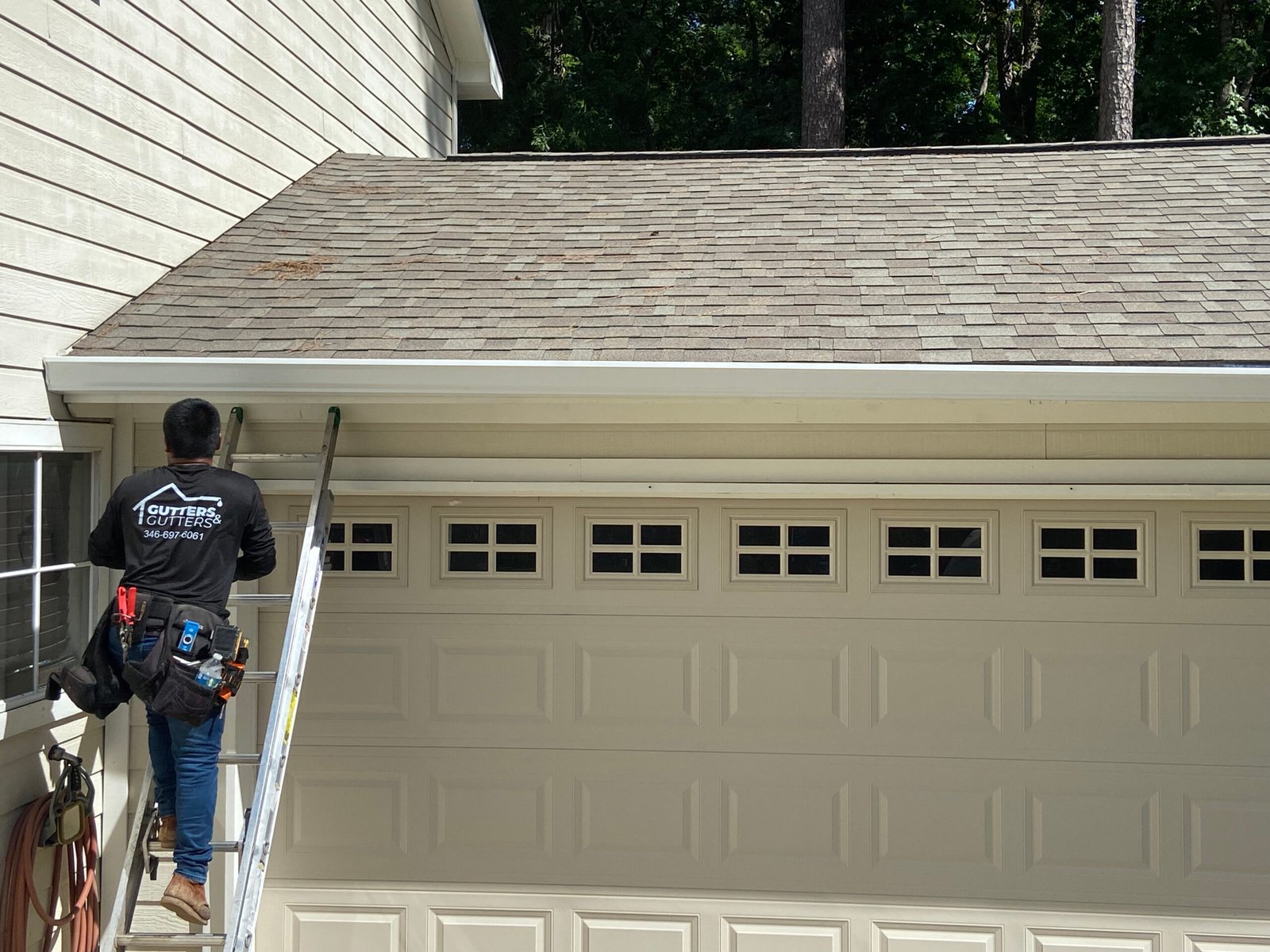 Man installing white gutters on a house - Gutters and Gutters (Seamless gutter specialist)