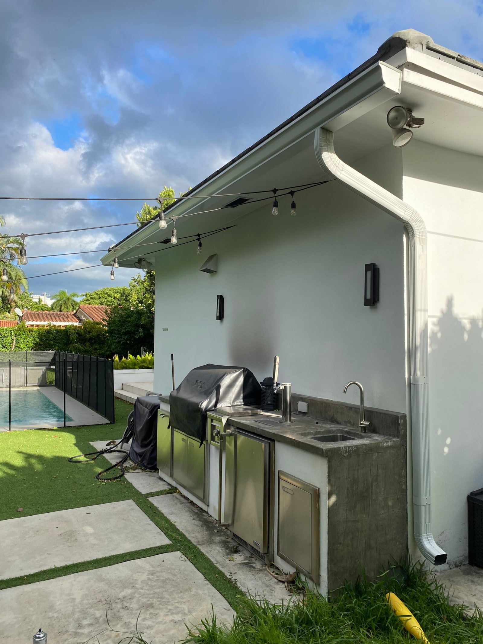An outdoor kitchen by a pool - Gutters and Gutters (commercial gutter repair)